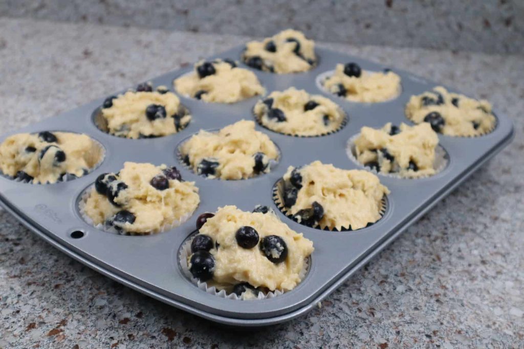 prepared tin with raw blueberry muffins ready to go in the oven.
