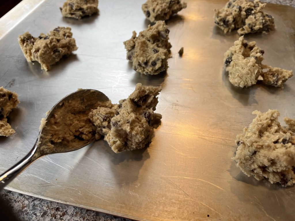 Cookie dough being spooned onto the baking sheet.