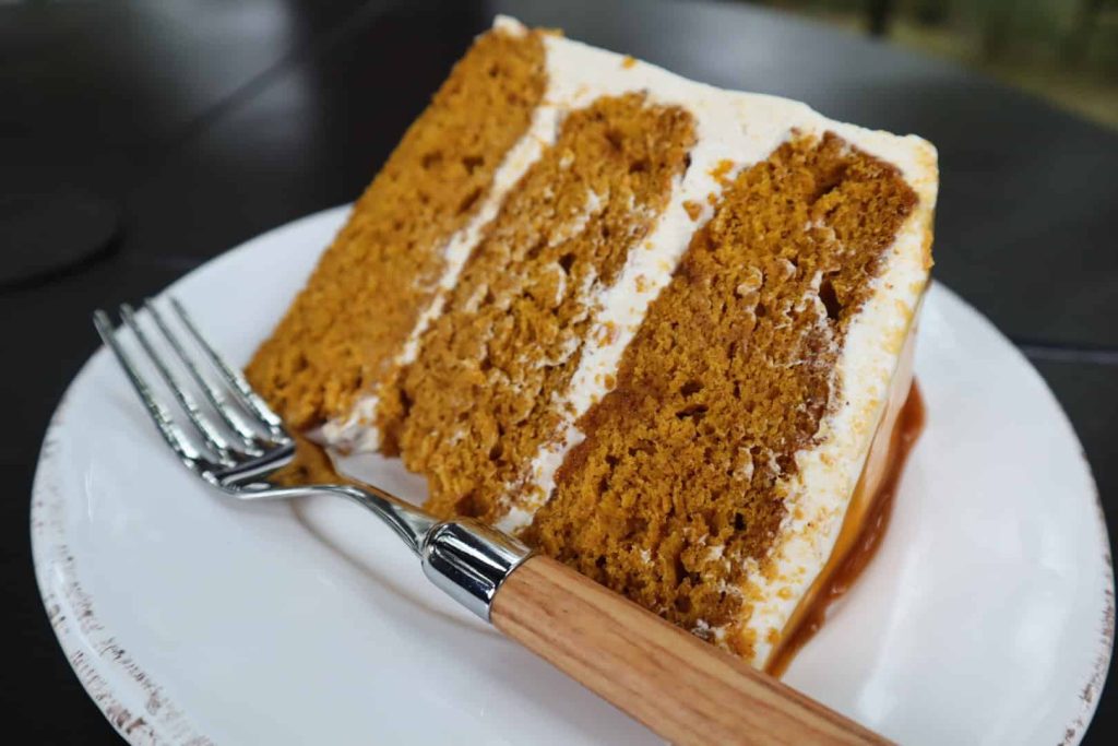 A single slice of Spiced Pumpkin Cake with Caramel Buttercream on a plate.
