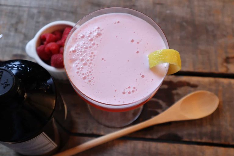 Top view of a foamy raspberry gin fizz cocktail