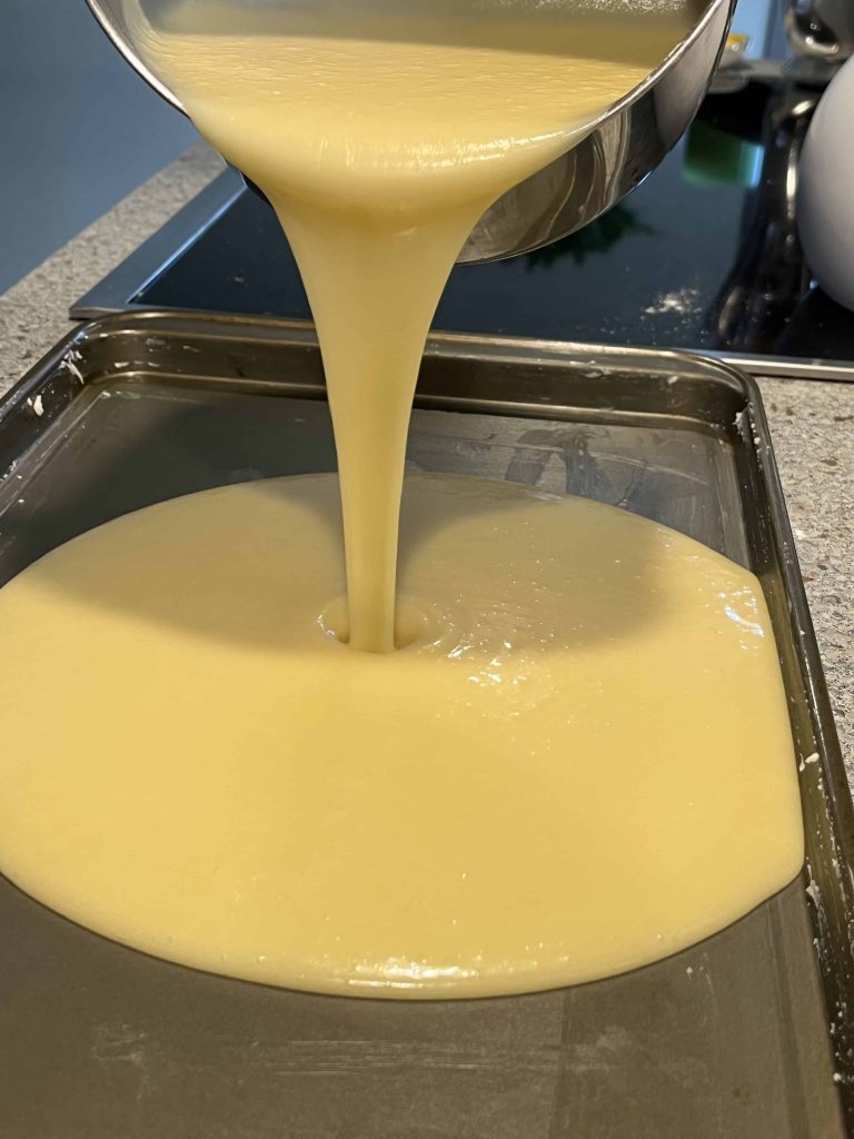 Pouring the batter into a rimmed baking sheet to make a Texas Sheet Cake.